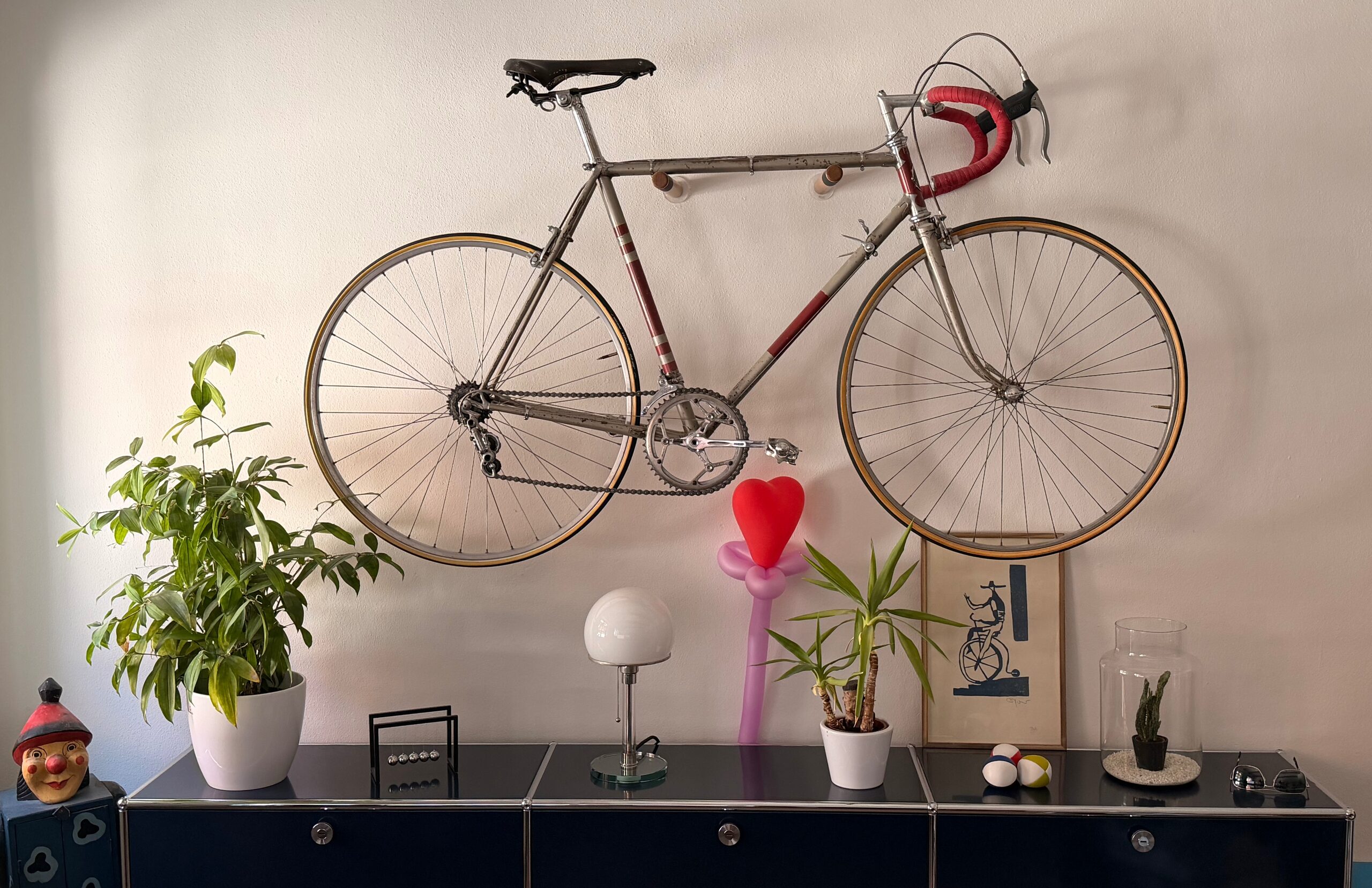 Rennrad an der Wand über einem Sideboard